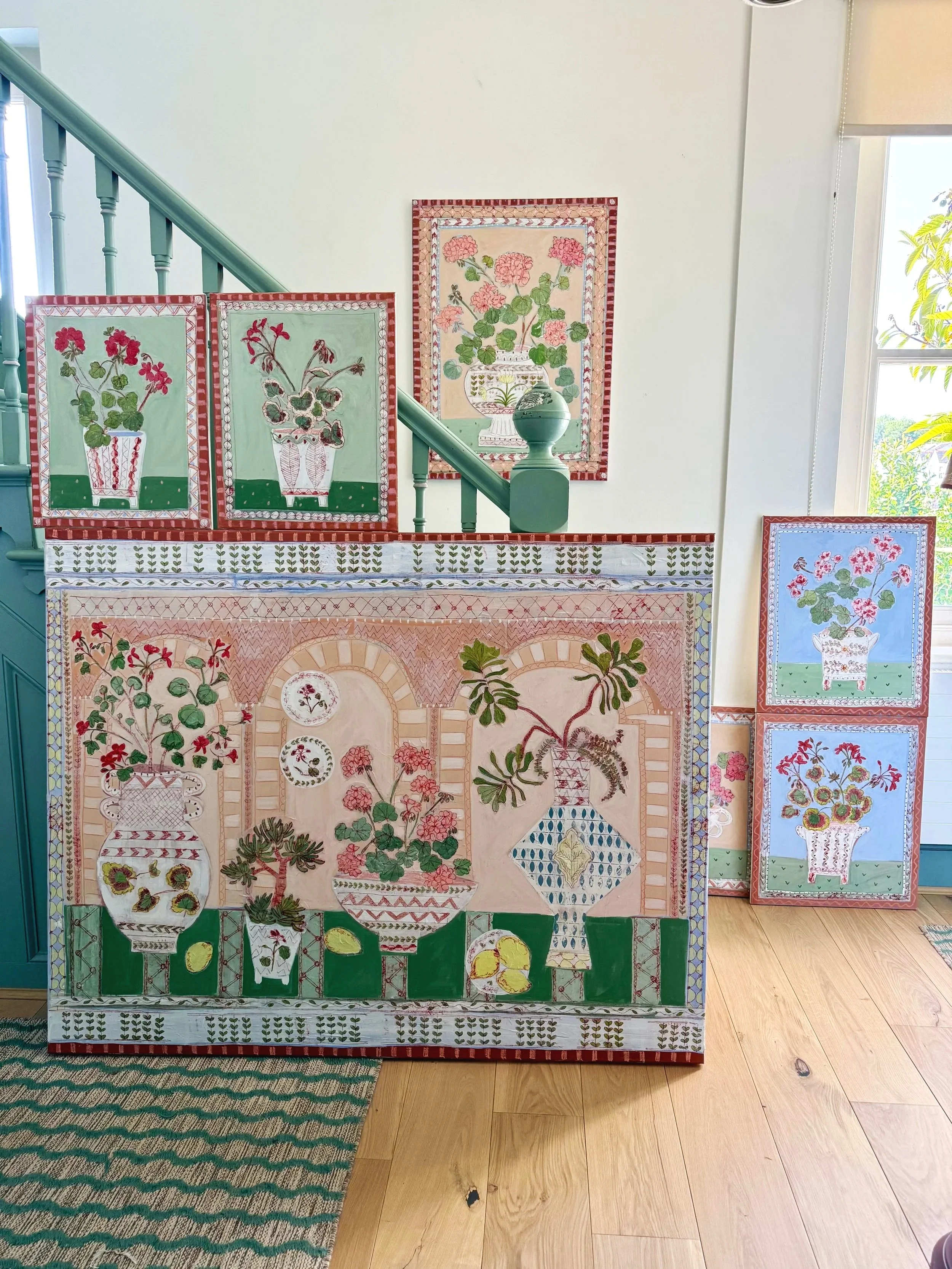 Close-up of three sheets of colorful, decorative paper with floral and geometric designs, layered on a wooden surface.