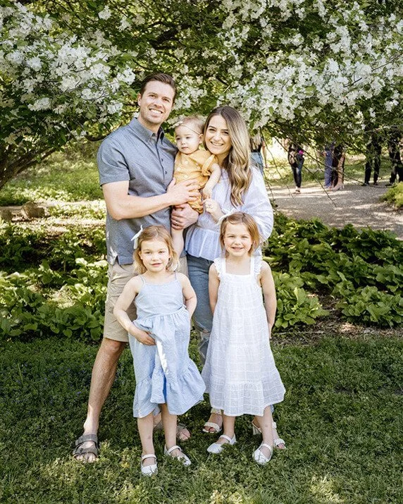 family posing in park for photo
