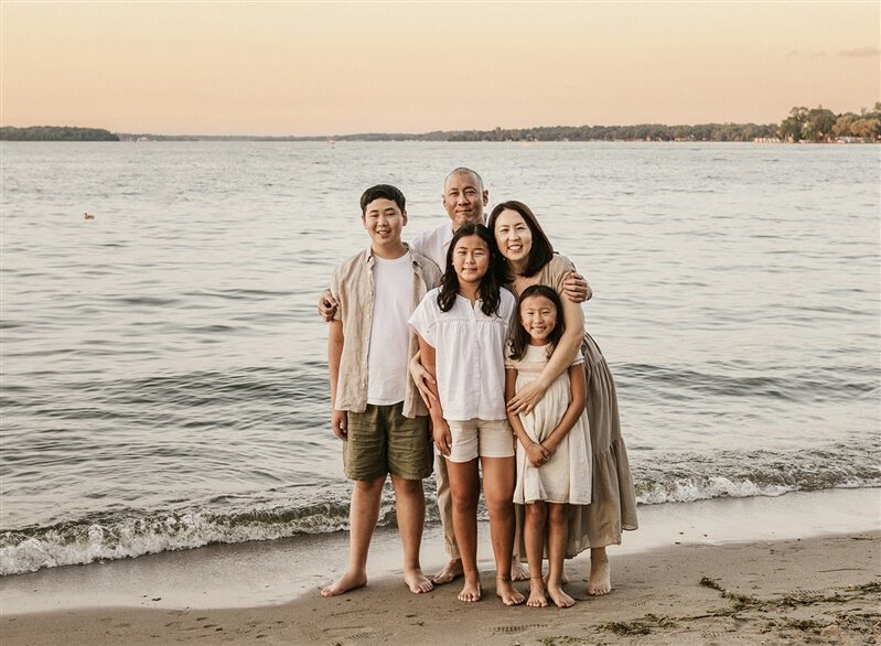 family posing for photo at oceanfront beach