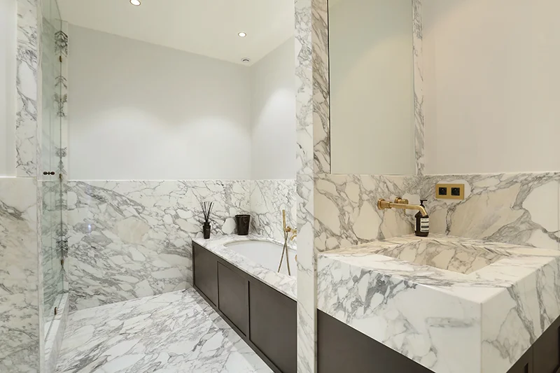 Salle de bain plage de baignoire plan vasque dallage sur mesure marbre arabescato mur Marbre de Carrare Appartement Parisien Omni Marbres