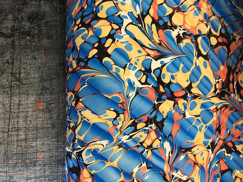 A sample of Jemma’s marbled papers in a bright blue and yellow ‘Spanish Ripple’ pattern.