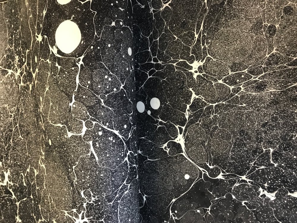 A sample of Jemma’s marbled papers in a black and white ‘space’ pattern.