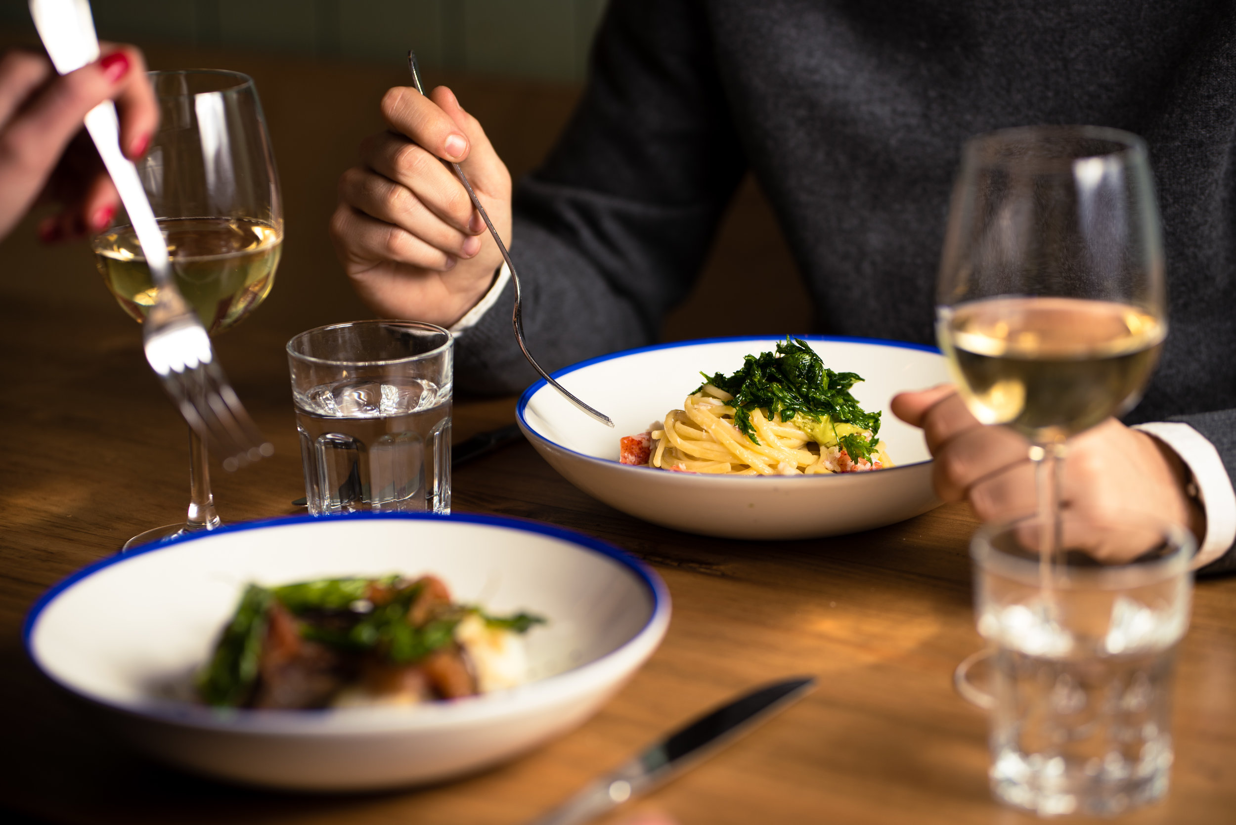  2 people eating pasta in a restaurant 