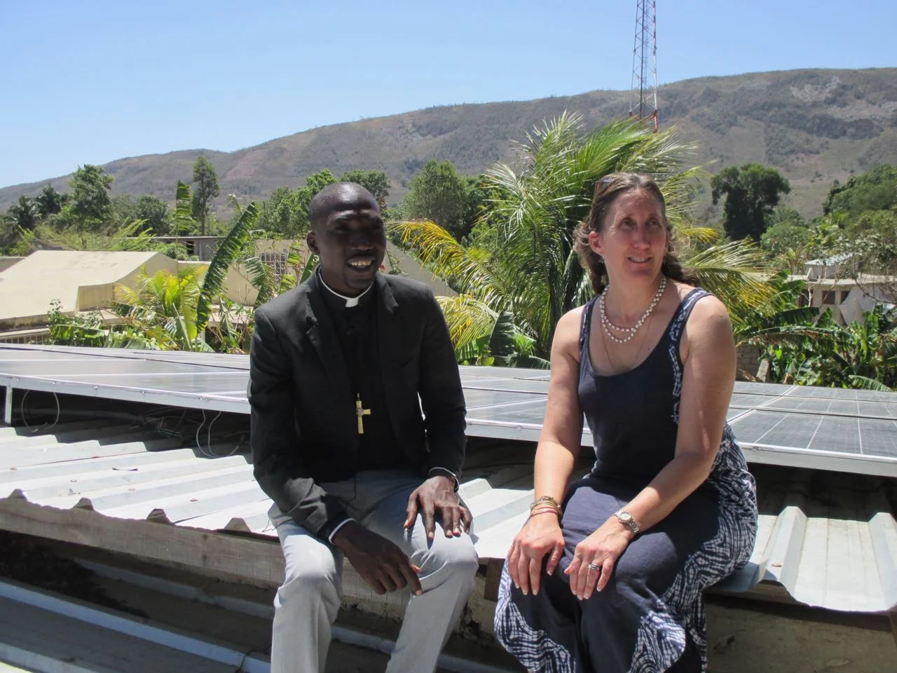 Deacon Schneyder Couloute and Dr. Delia Heck examining the 10 kWh solar system installed at St. Marc, Cerca la Source in March 2018.