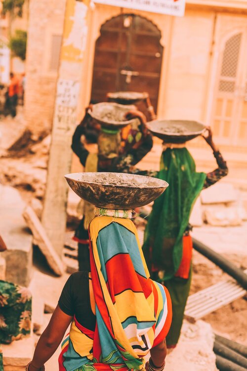 Indian women in saris caring bowls on head celebrating international womens day small.jpg