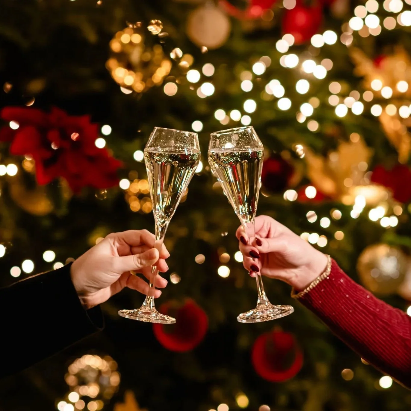 A cheers with two glasses of champagne with a christmas tree in the background at 116 Pall Mall