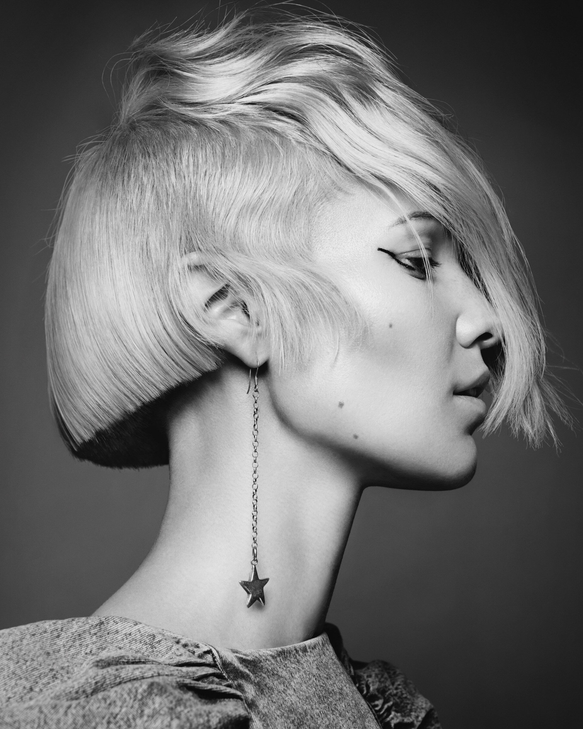 A woman in a photography studio with a short blonde hair style