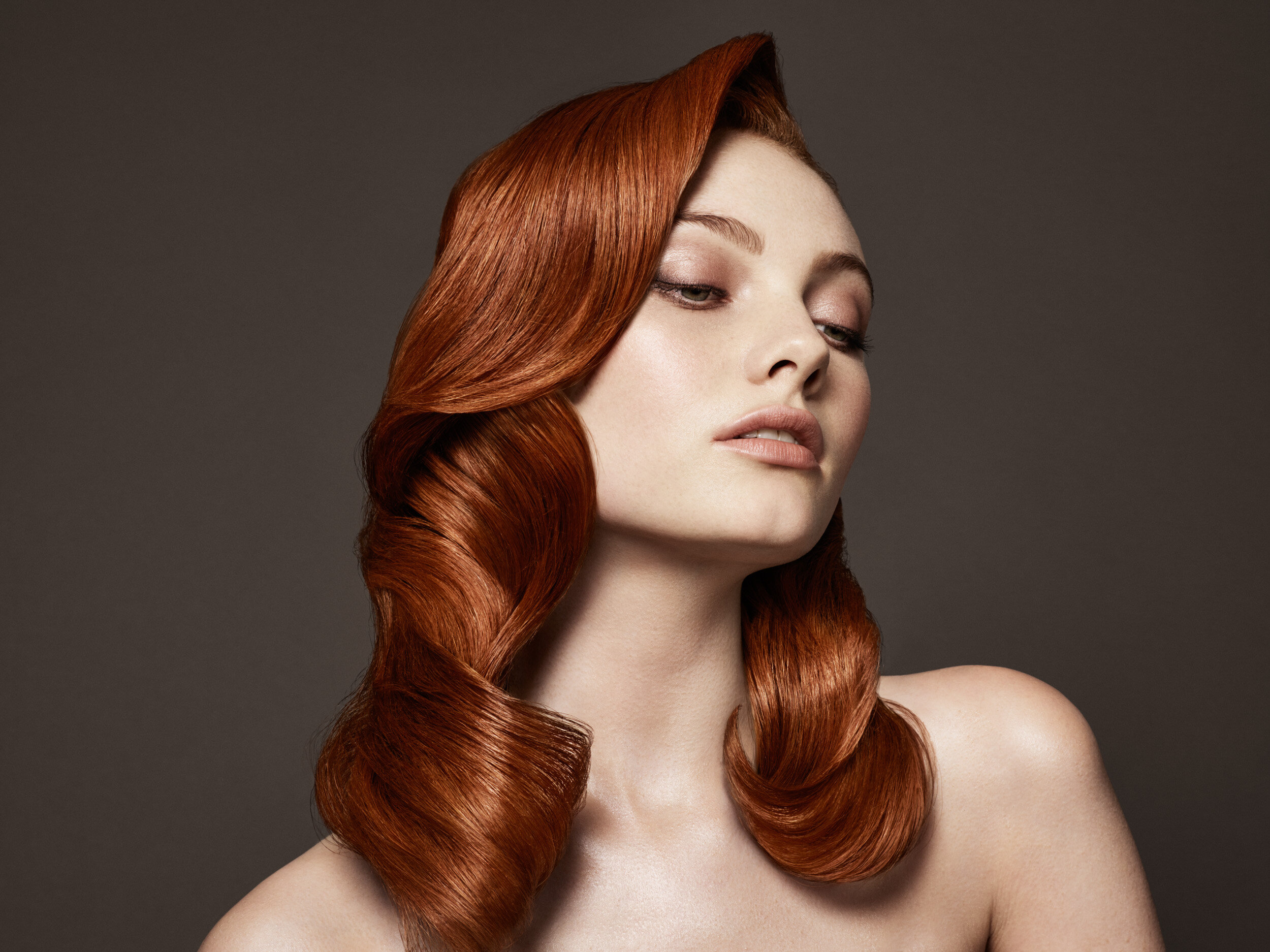 Redhead woman in studio with long shiny hair 