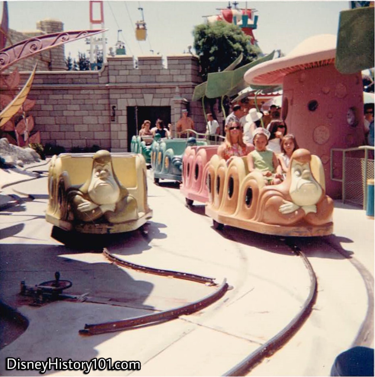 Guests aboard Caterpillars and a "cycled-out" Caterpillar of Alice in Wonderland; 1968.