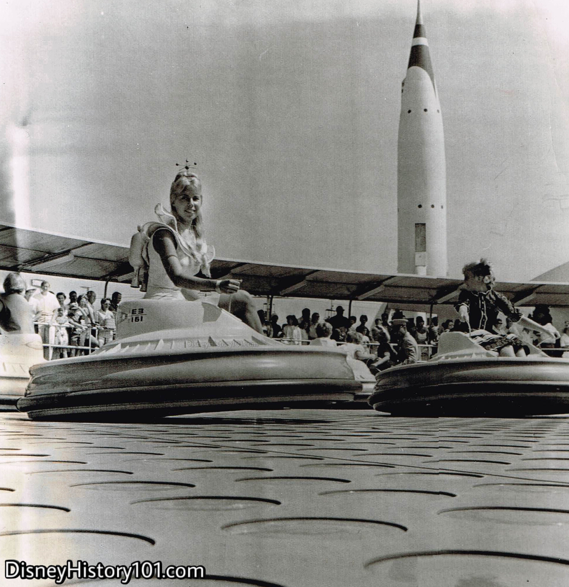 Donn Fox extends a courteous smile as she pilots a Flying Saucer at “the Happiest Place on Earth” on August 14, 1961; Photo Credit UPI Telephoto, Collection of Disney History 101.