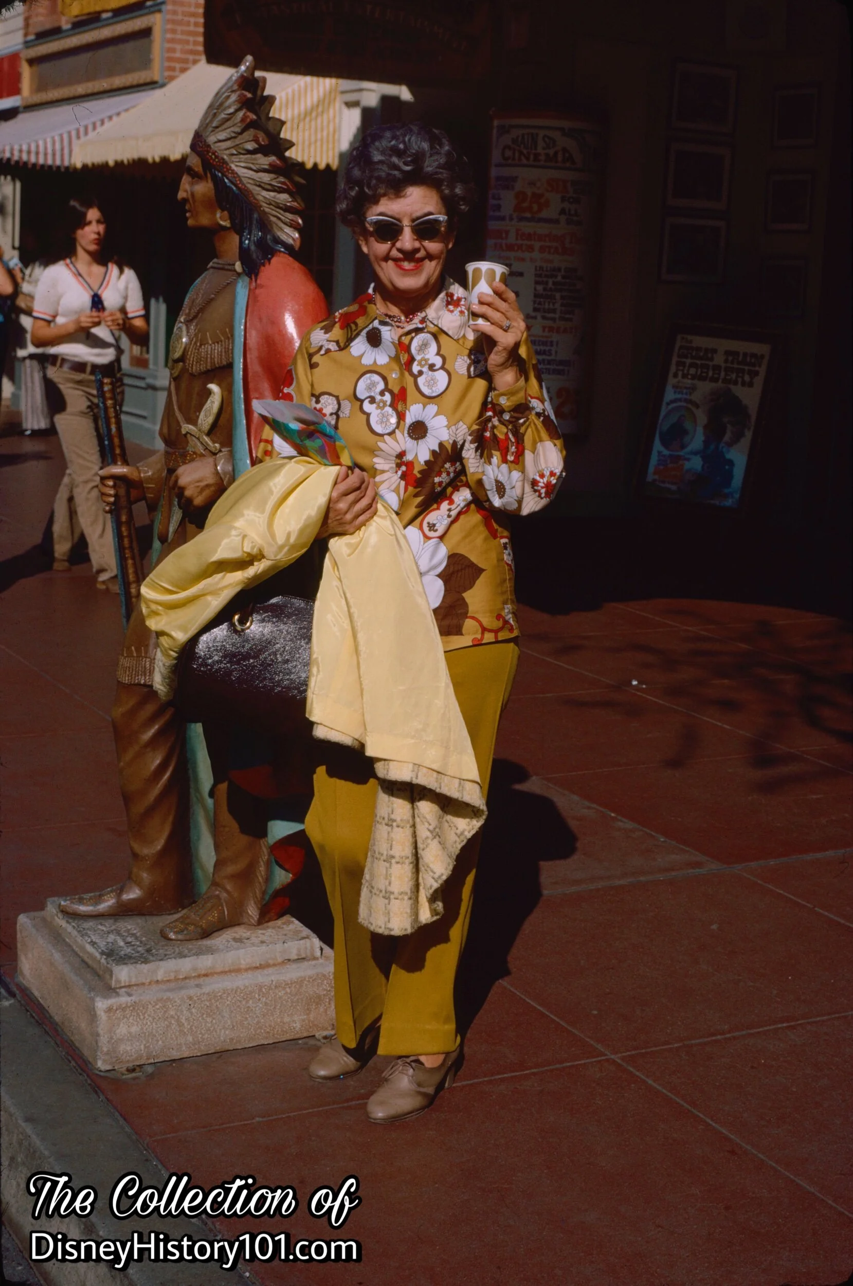 MAIN STREET TOBACCONIST SHOP INDIAN and a guest holding her souvenirs of Disneyland, October 30, 1971.