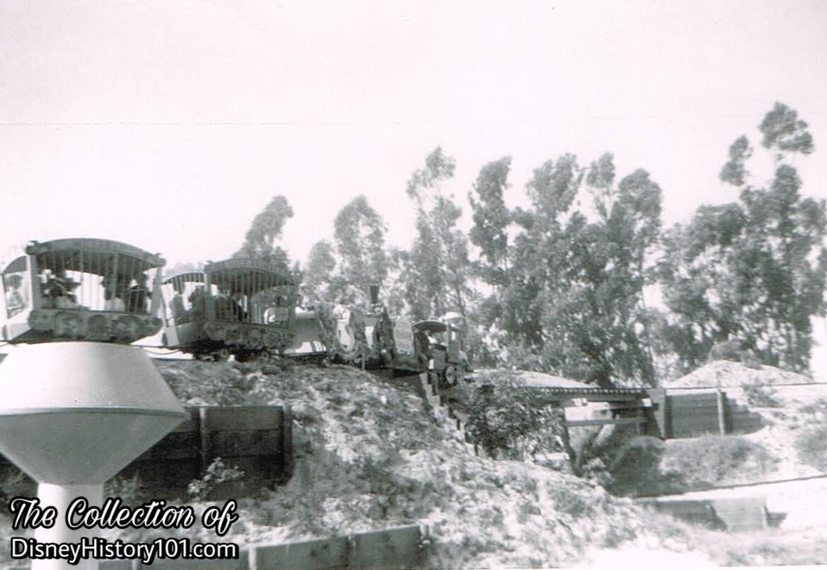 A Casey Junior Circus Train prepares to pass over a trestle bridge, near the out-of-scale eucalyptus tree "wind break," (August, 1955)