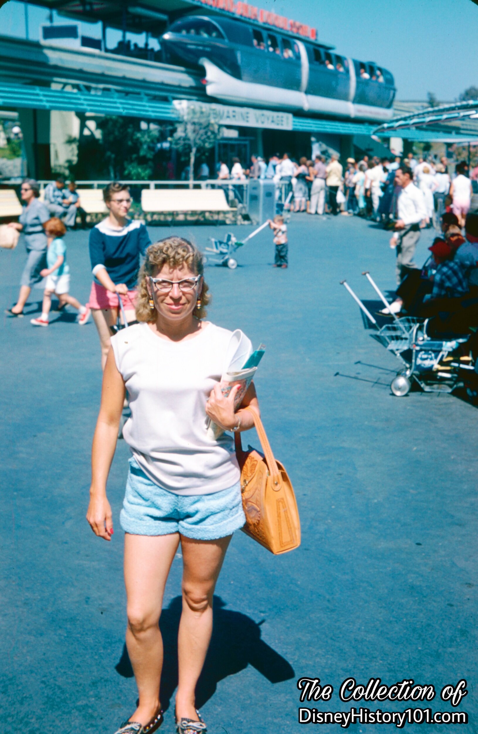 A Disneyland Guest stands near the Monorail Blue Mark I at Tomorrowland Station.