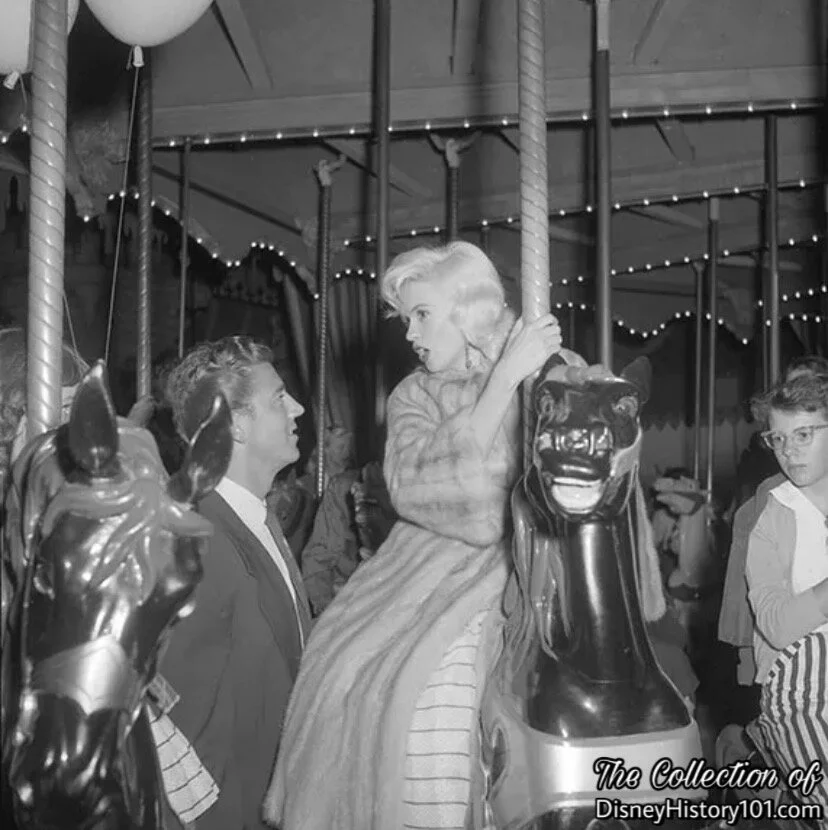 Jayne Mansfield and Mickey Hargitay aboard King Arthur Carousel as it spins gaily.