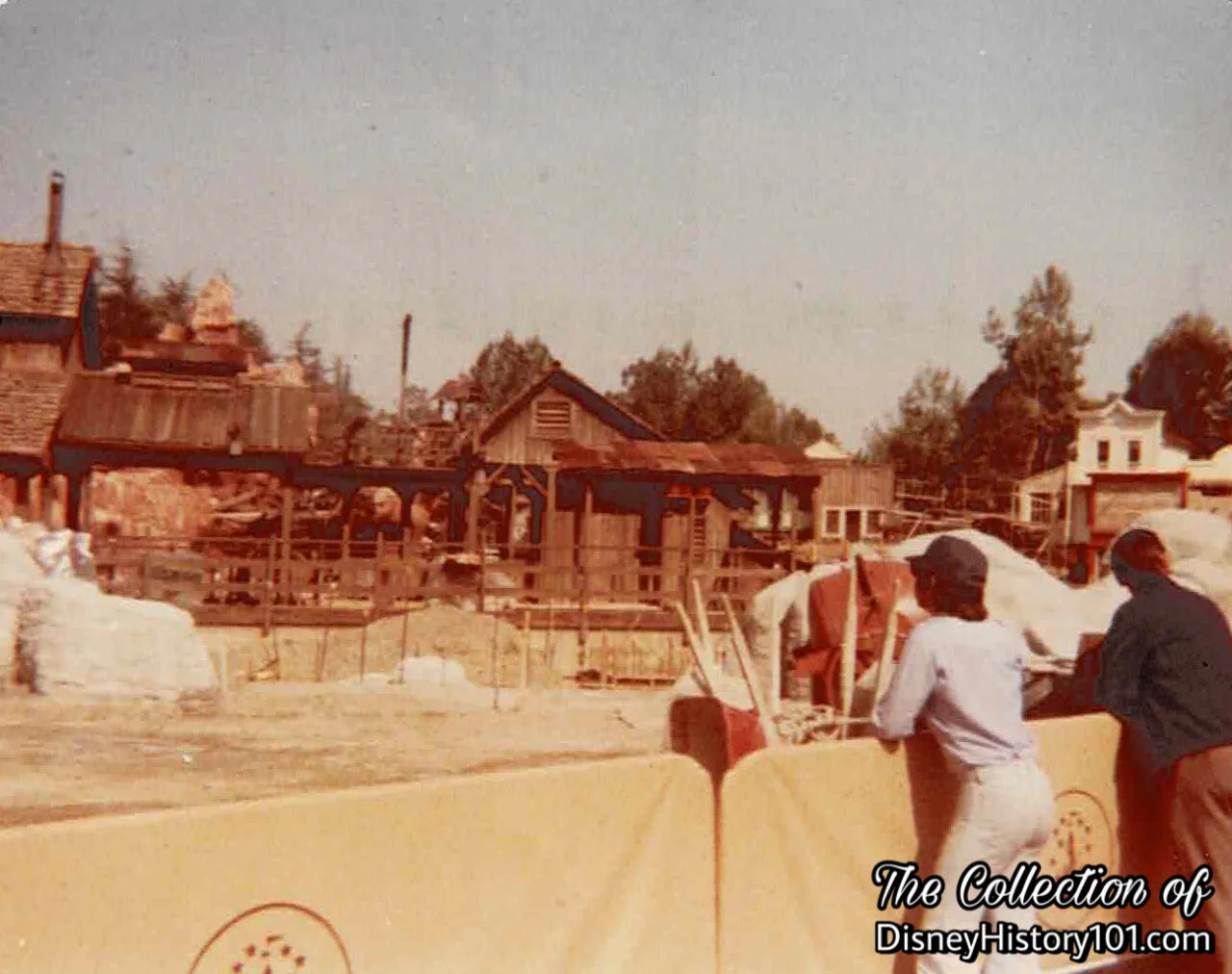 A couple of “sidewalk inspectors” pause to take in the Big Thunder Mountain Construction from the Guest Control barricade near the perimeter.
