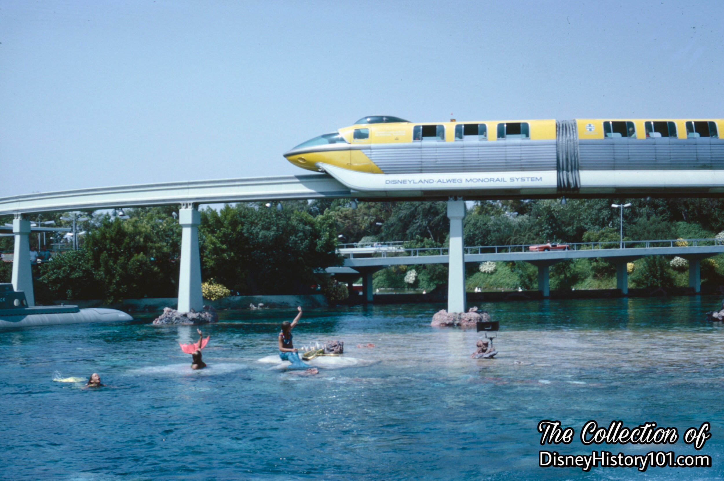 REENTERING THE PARK AND TOMORROWLAND SEGMENT - Mermaids from Mythical Times greet the Monorail Mark II Yellow.