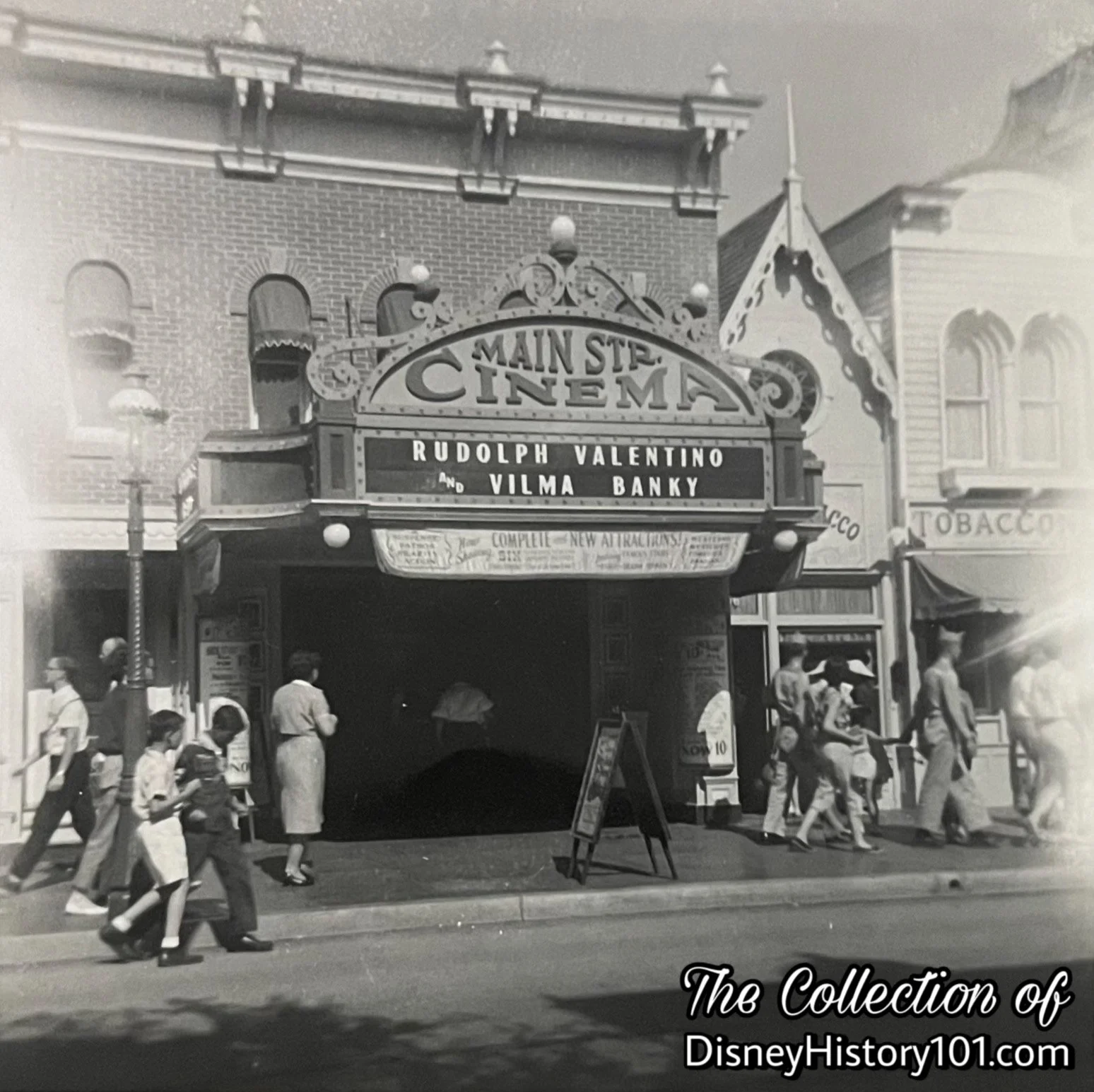 The Main Street Cinema marquee simply features the names of silent film, legends Rudolph Valentino (1895-1926) and Vilma Banky (1901-1991); July of 1957.