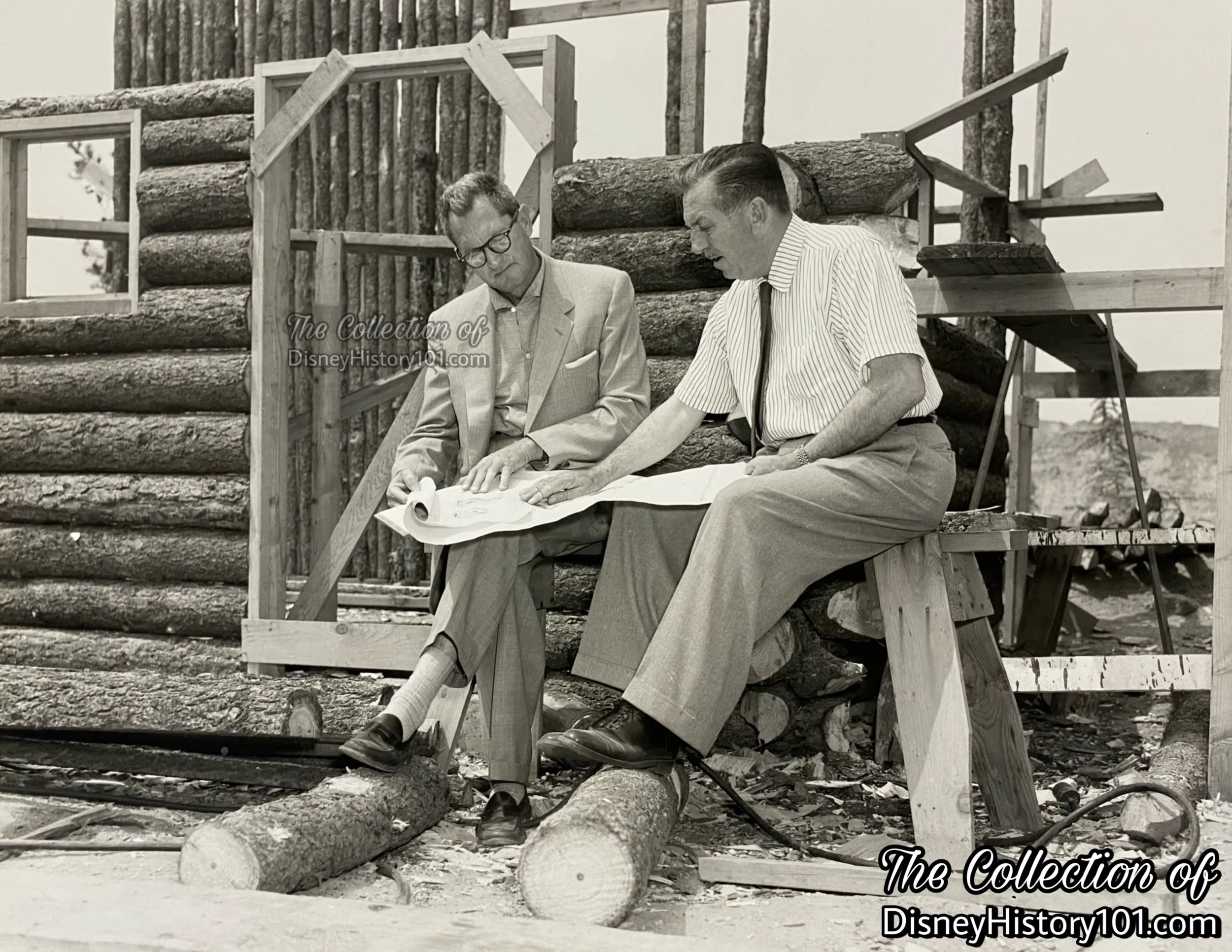 A press release photograph captures Vic Greene and Walt Disney with some of those hand-hewn logs, May of 1956; ©️Walt Disney Productions.