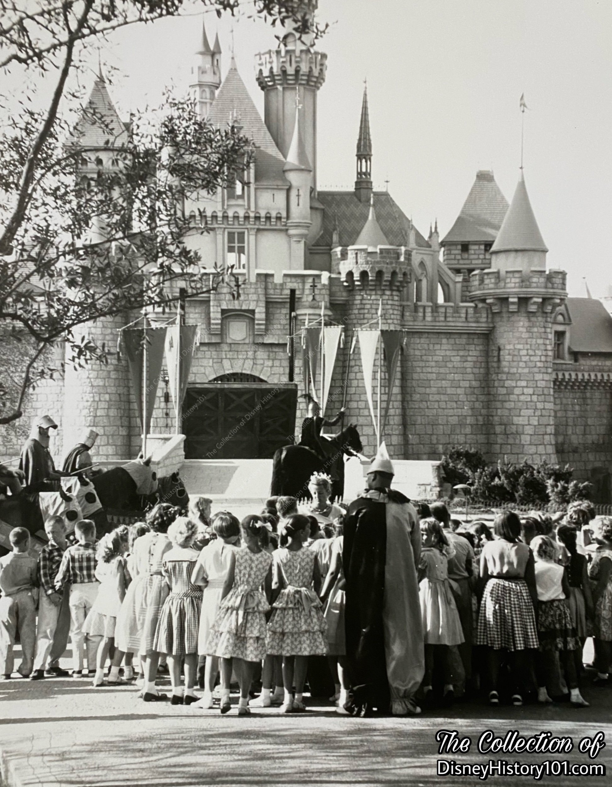A press release photo gives a rare glimpse of the raised drawbridge and crowds in Sleeping Beauty Castle Forecourt; ©️Walt Disney Productions.