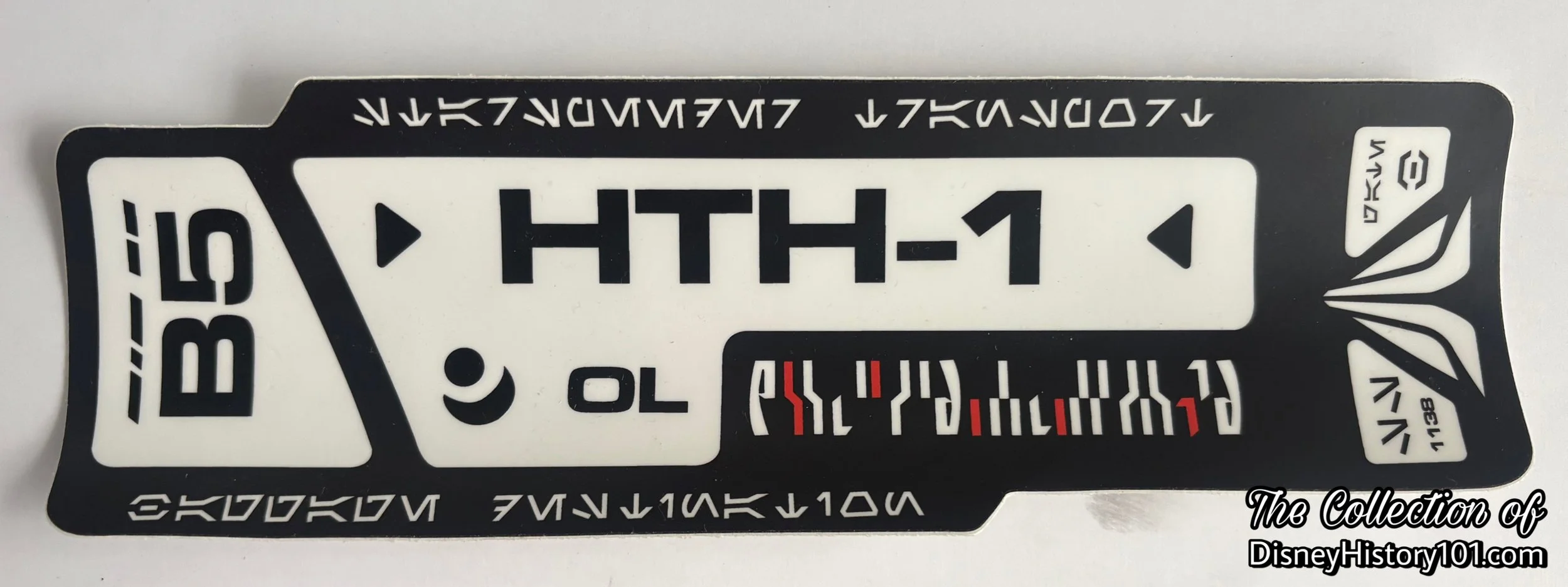 A Star Tours Set Dressing Decal reading “StarSpeeder Transport… SS 1138… Gate B…Baggage Destination” in Galactic Standard Aurebesh.