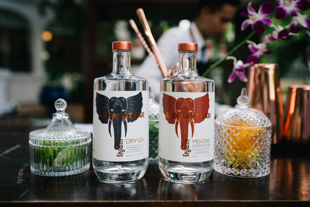 Elephant Bar Dry Gin and Mekong Strength Gin bottles on the bar at Raffles Hotel Le Royal