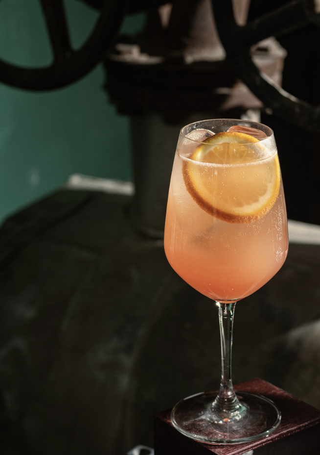 Gold Spritz in a wine glass with orange zest