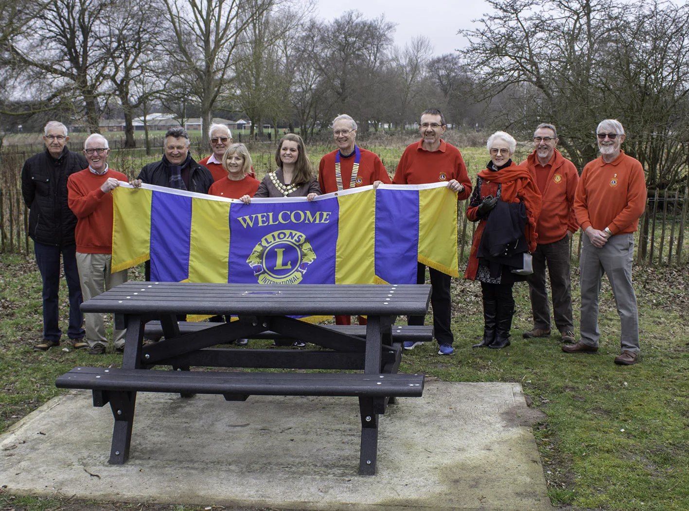 Lion President Chris Lambert and the Mayor of Beccles - Cllr Elfrede Brambley-Crawshaw in the centre surrounded by members of Beccles Lions Club and friends at the Presentation of the Picnic Benches.