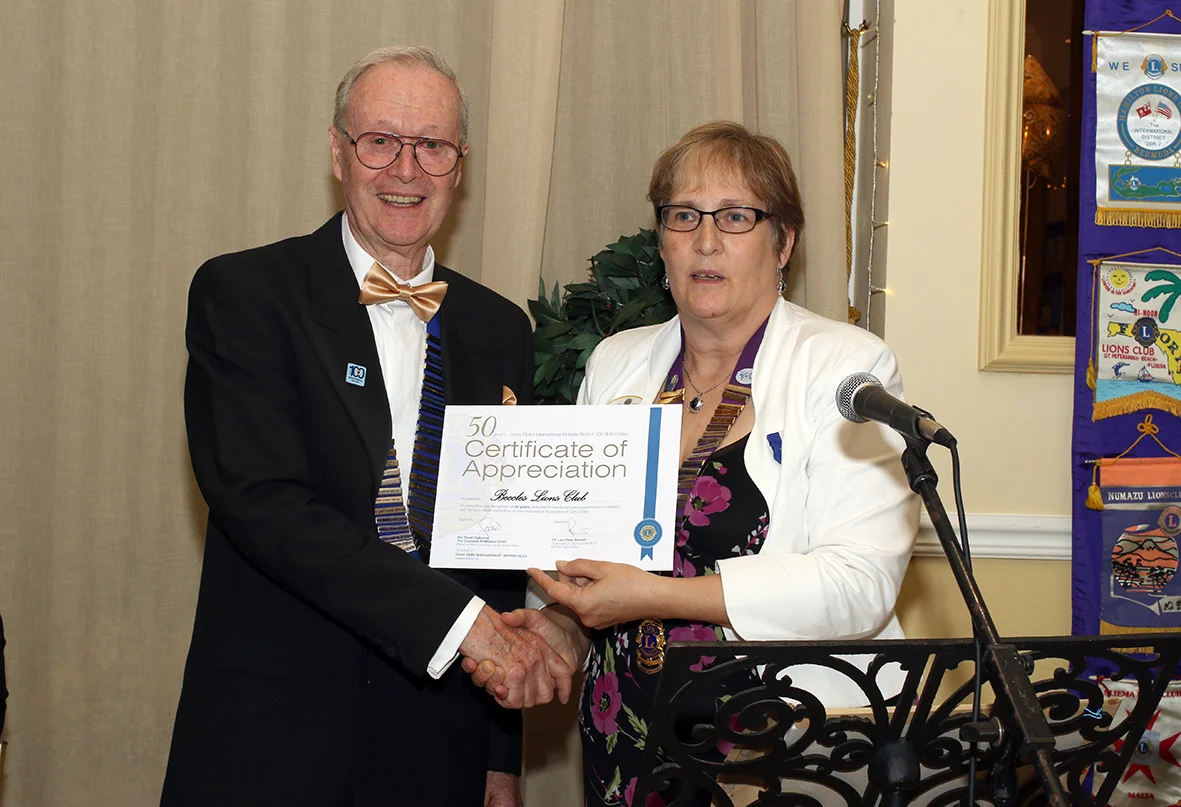Lions International District Governor for East Anglia - Lion Mandy Hawkesley presenting the 50th Anniversary Certificate of Appreciation from Lions International to Beccles Lion President - Chris Lambert.