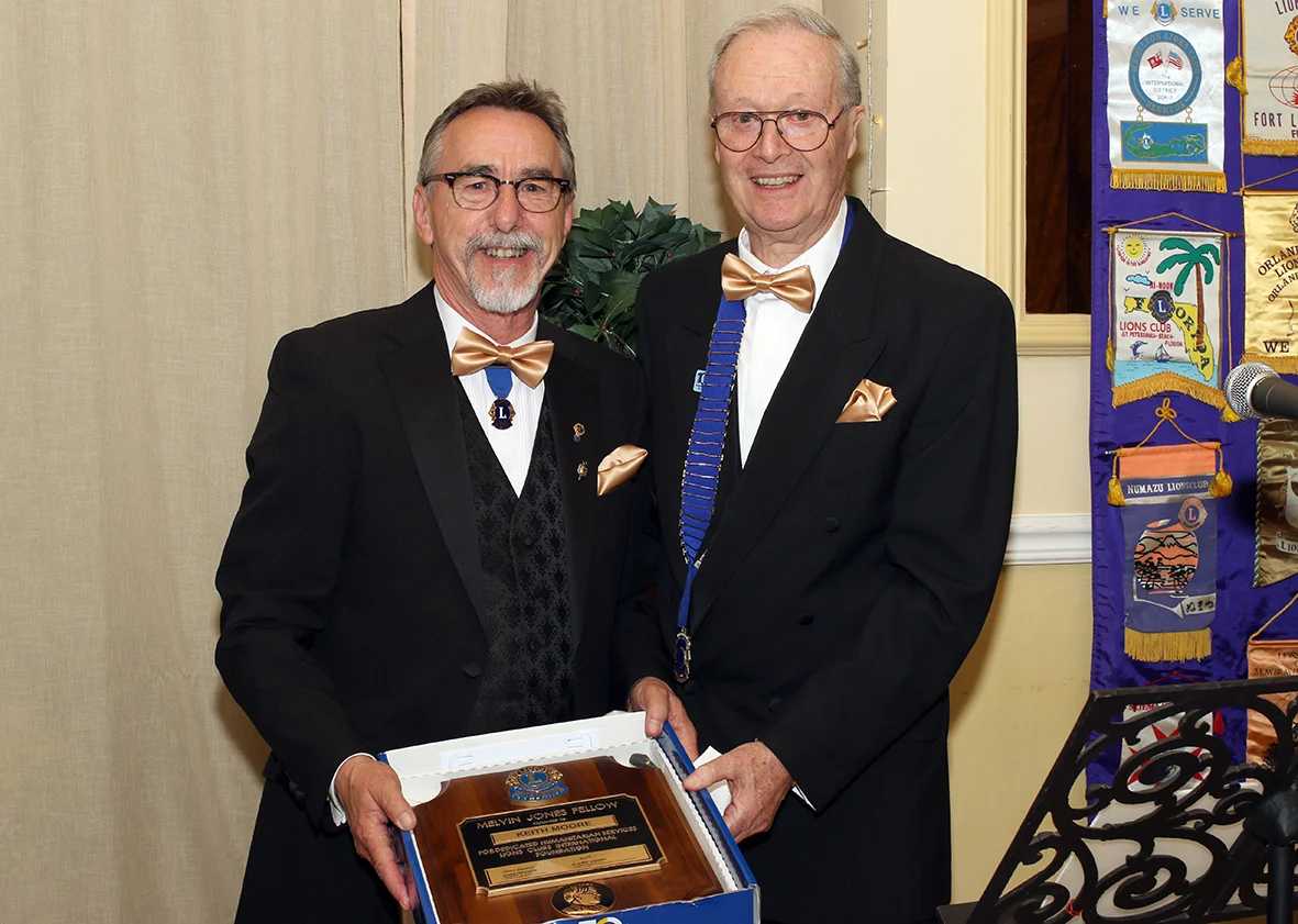 Lion Keith Moore (left) receiving the commemorative ‘MJF’ plaque from Lion President Chris Lambert.