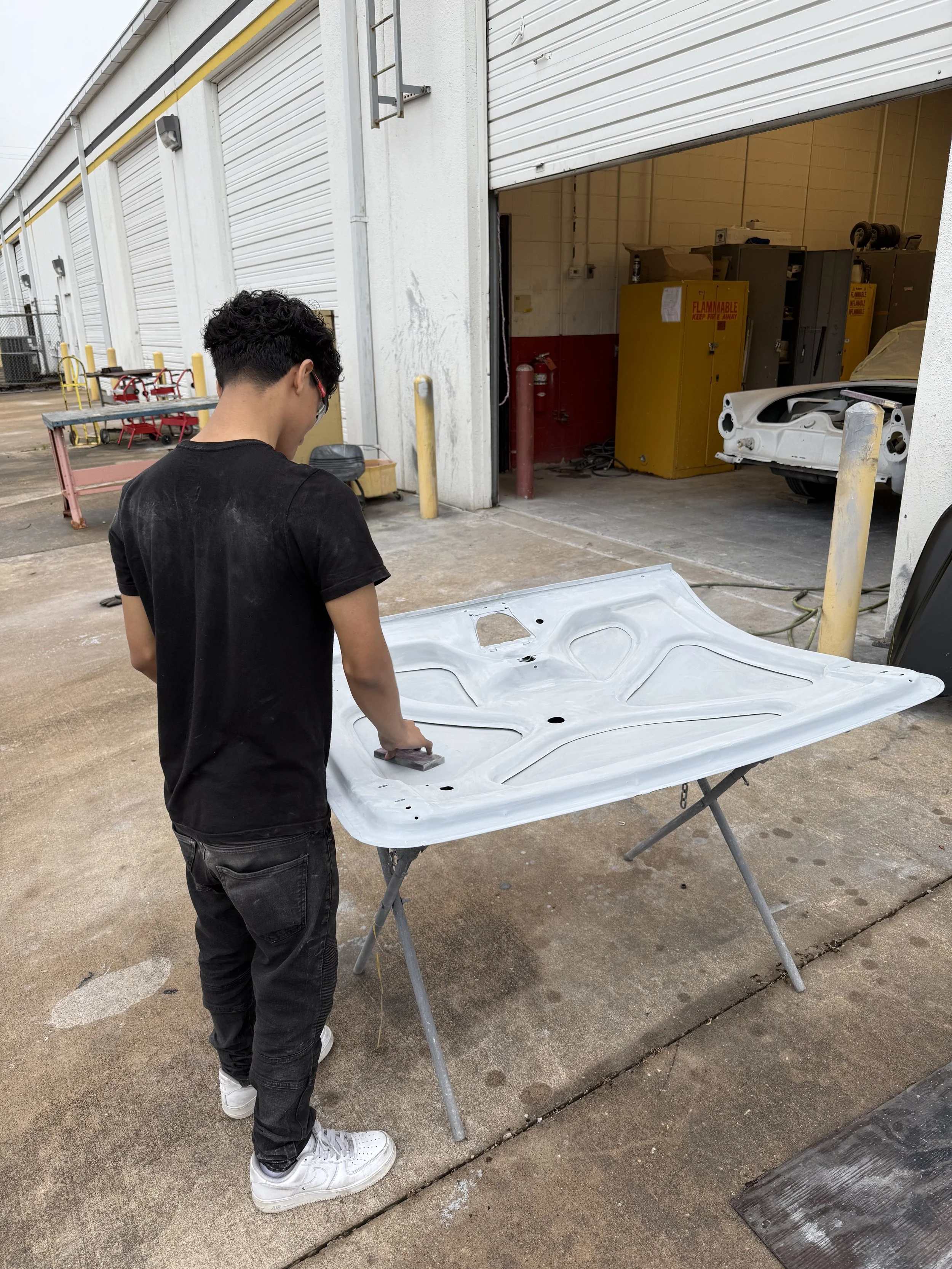 Student sanding making ready for final prime coat before color.