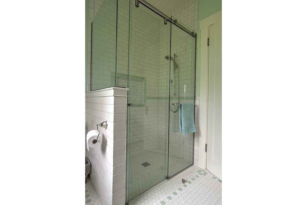  A no-curb shower is accented with a floral pattern in the octagonal tiles typical of early 20th century design. 