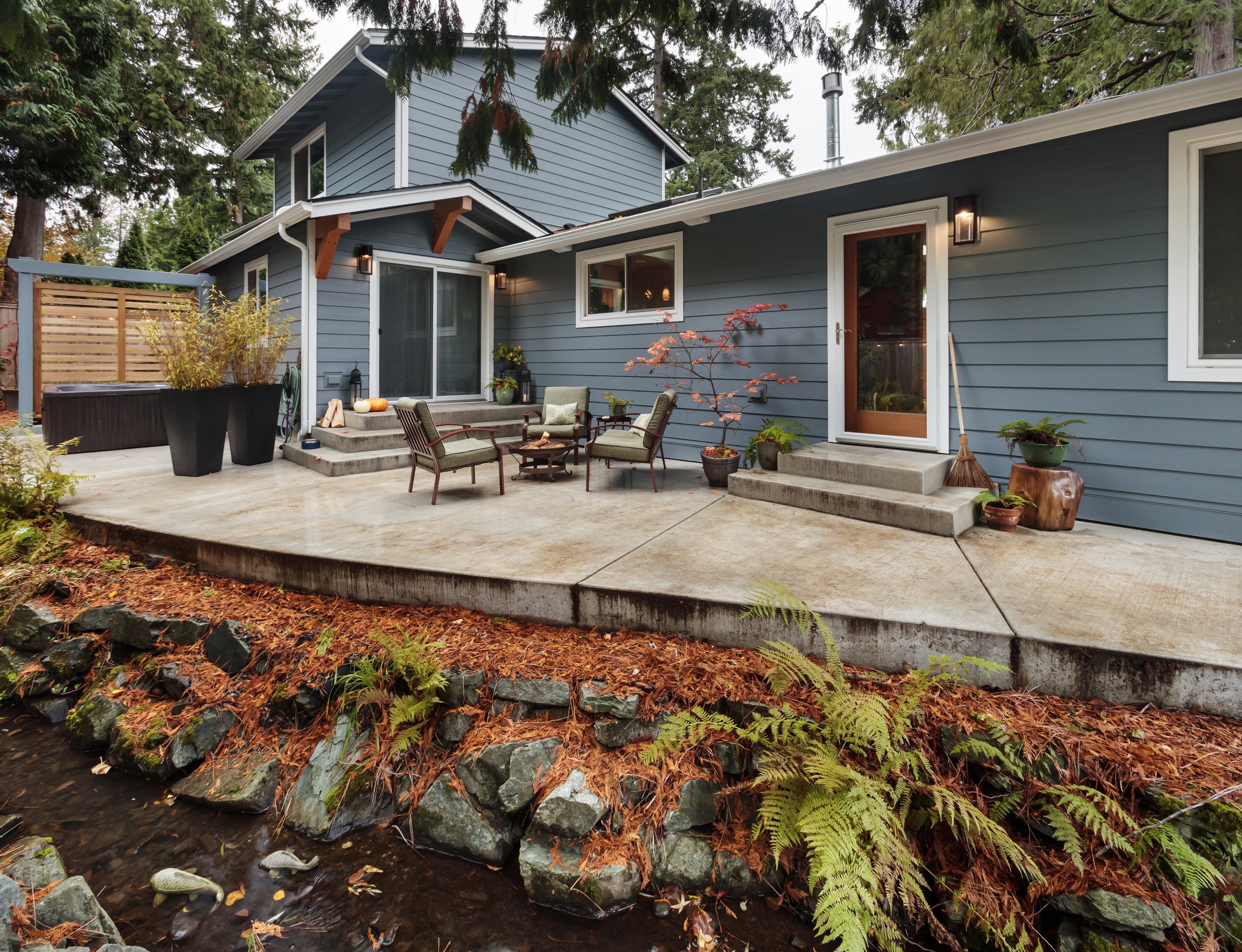  Using poured concrete for the new patio allows for a sinuous shape that follows the lovely creek running through the Cook’s back yard, and creates a natural connection to the new steps and landings that also minimizes maintenance. 