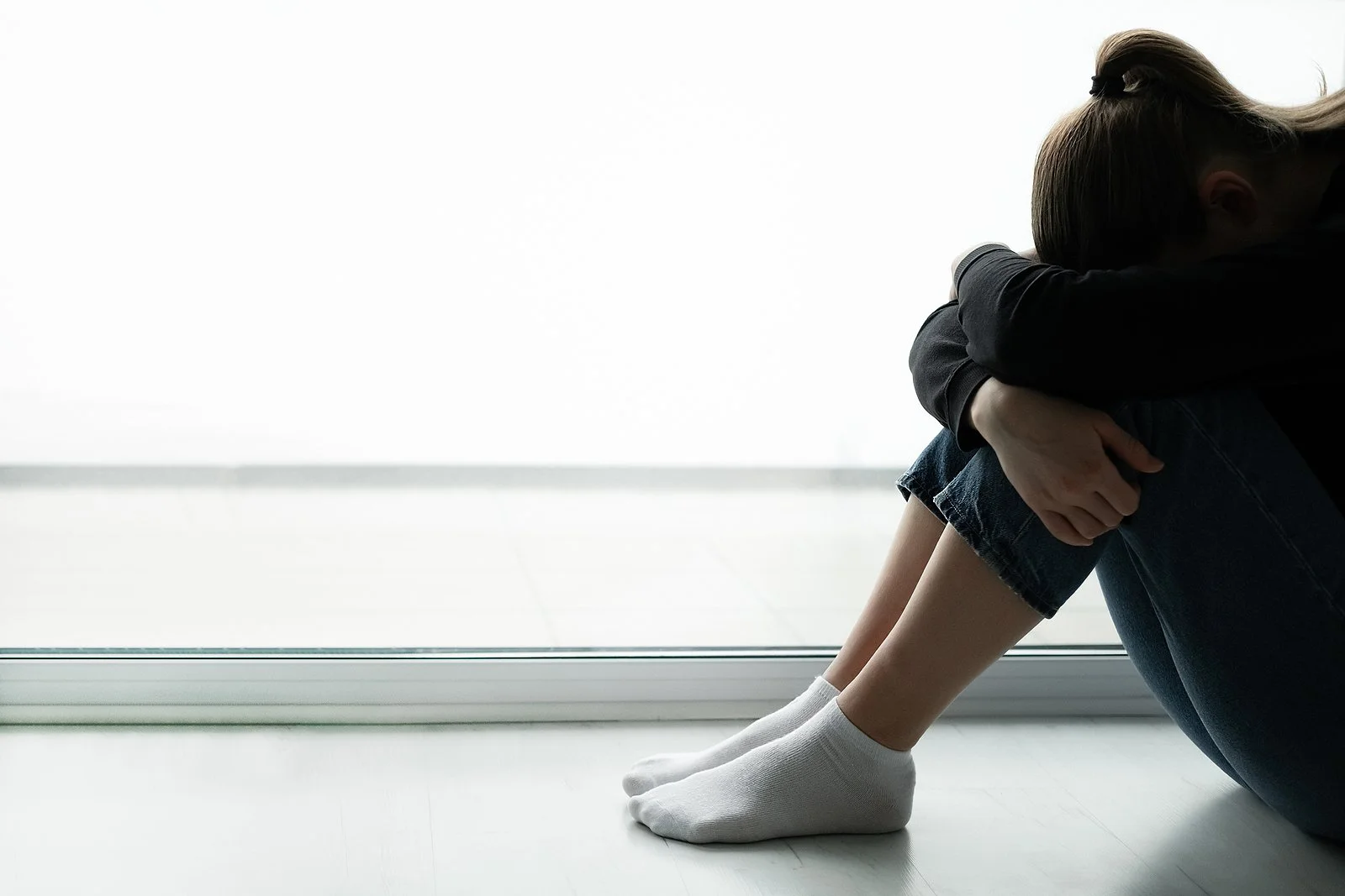 A woman holds her legs in the fetal position. Learn how a trauma therapist in Los Angeles, CA can offer support with overcoming past trauma. Search for ptsd treatment and trauma therapy in san francisco, ca for support with how to cope with eating di