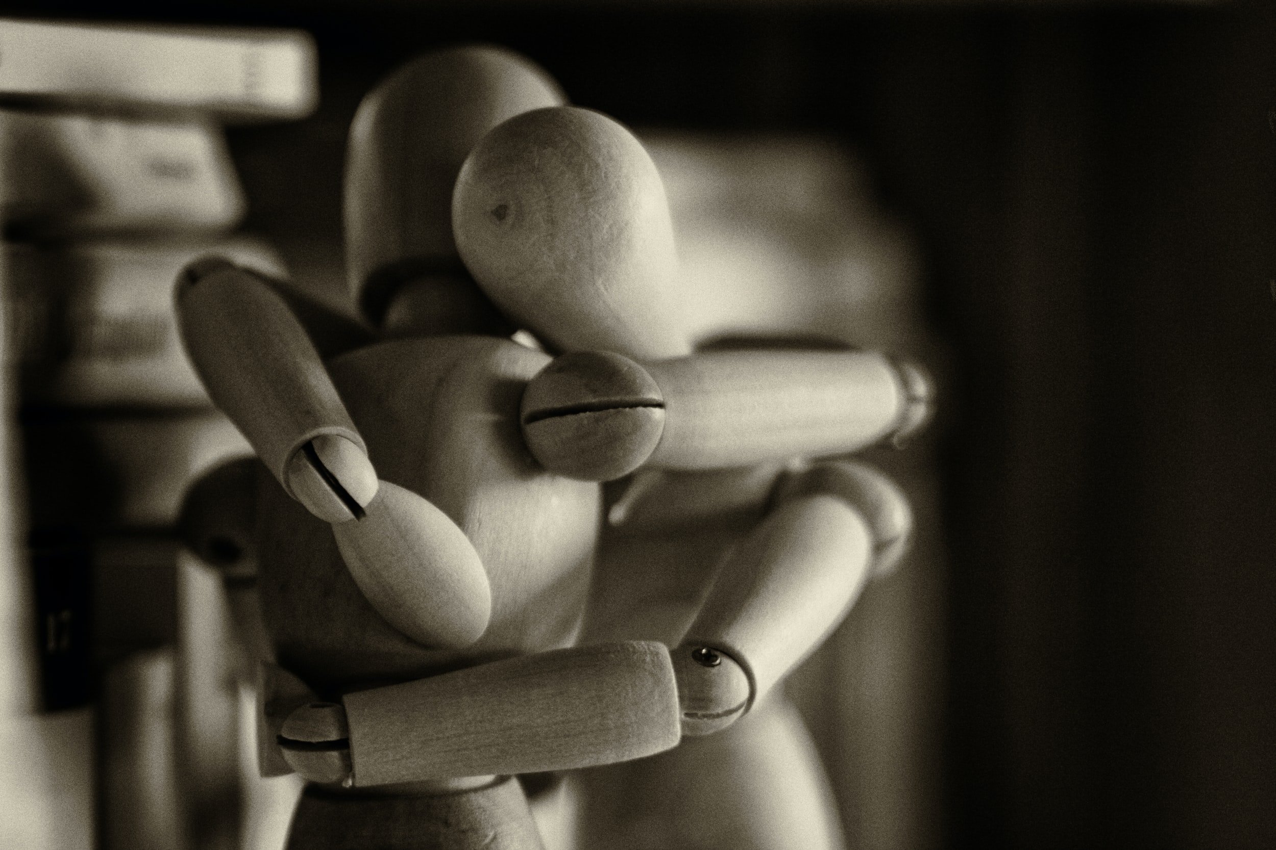 Photo shows an image of two wooden figures hugging. This photo represents how trauma can hurt but healing is important. Learn how trauma and eating disorder treatment in California can help you heal.