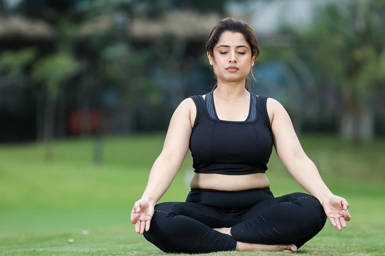 Woman in lotus yoga pose, leaning into mindfulness through CBT for eating disorders