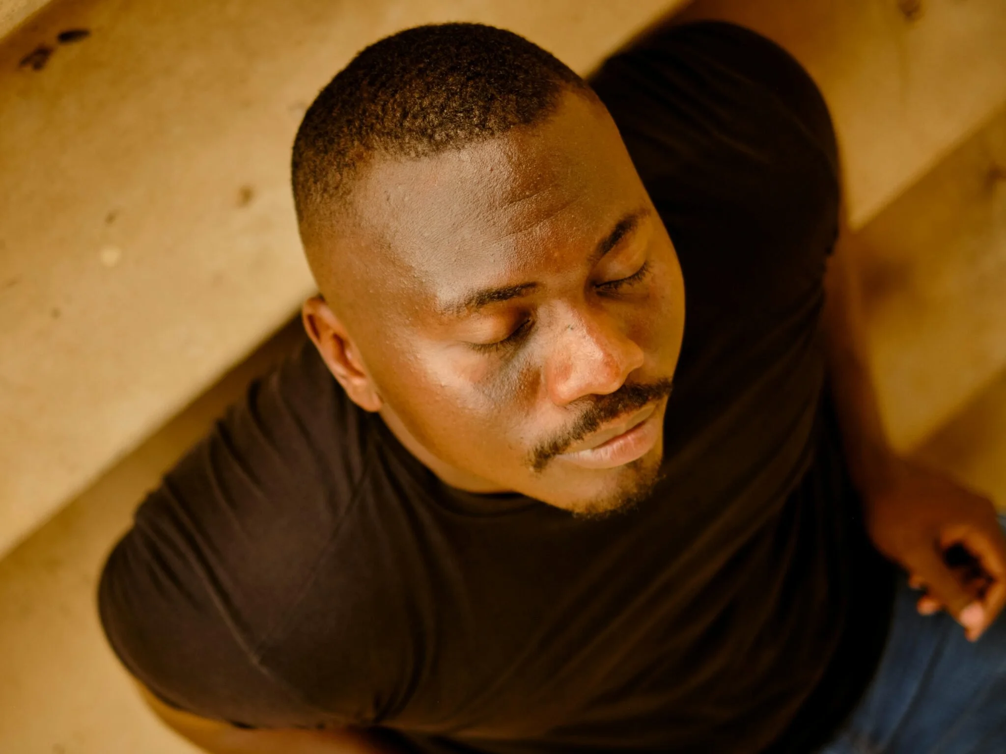 Close-up of a man with eyes closed, sitting in quiet reflection—capturing mindfulness, breathwork, and the power of inner calm in managing stress during eating disorder recovery.