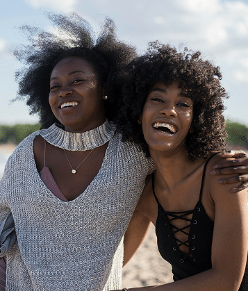 Two women smiling together, representing connection, support, and healing through online eating disorder therapy