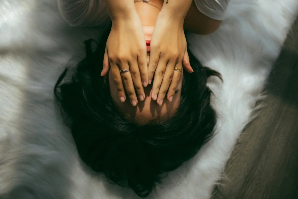 Woman with hands covering her face, wondering what is food noise?