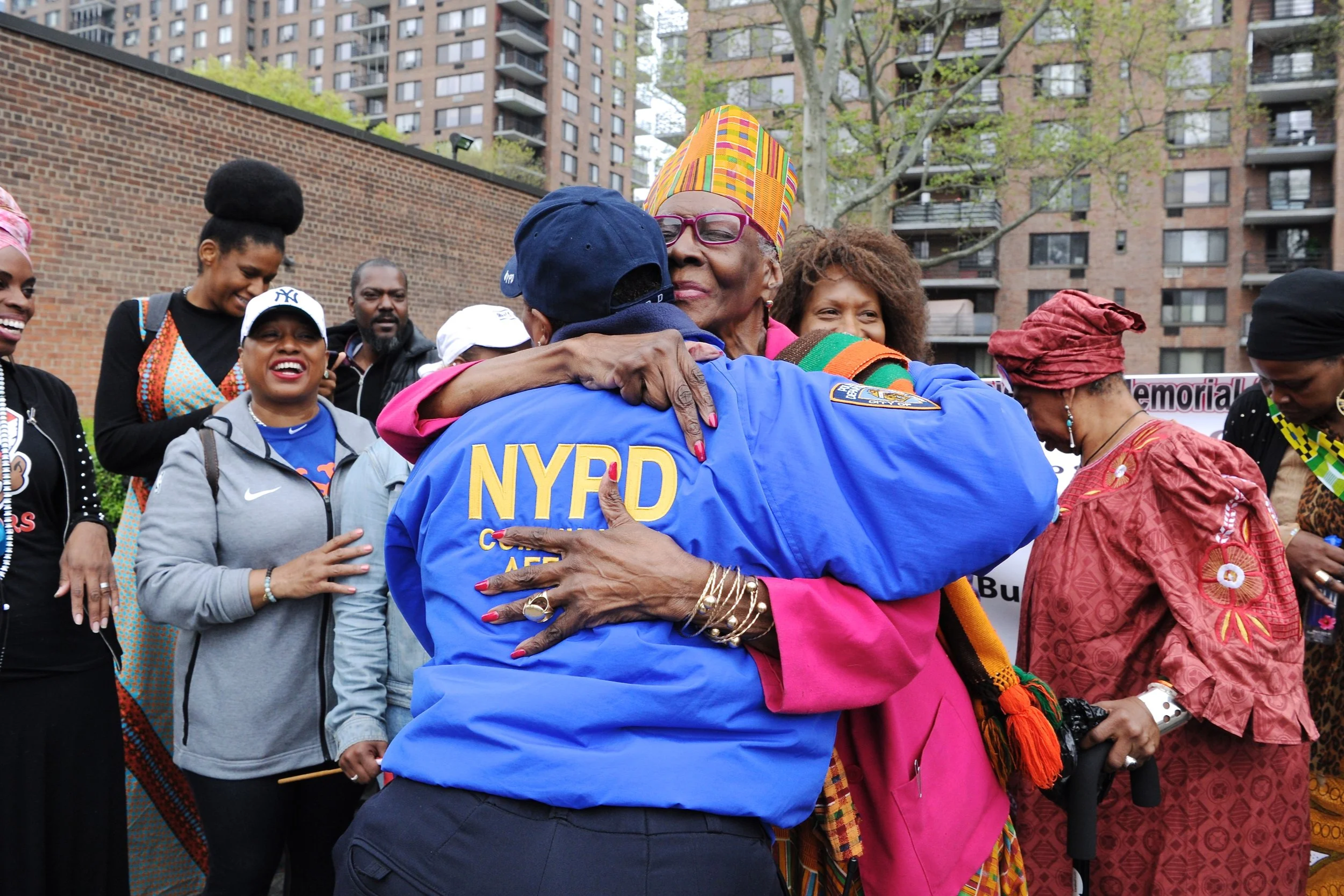 Candace Queen Mother Abbess-Bishop Shirley Pitts hugging NYPD officer  