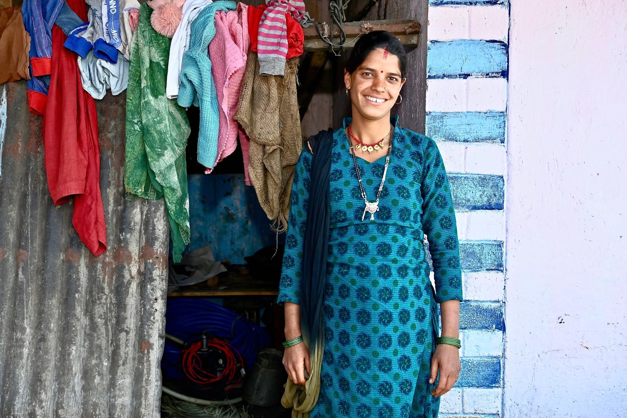 Aisha in front of her house