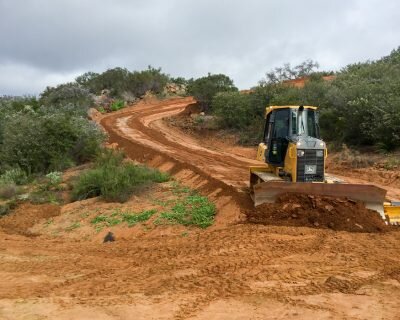  A bulldozer pushing dirt down a hill. 