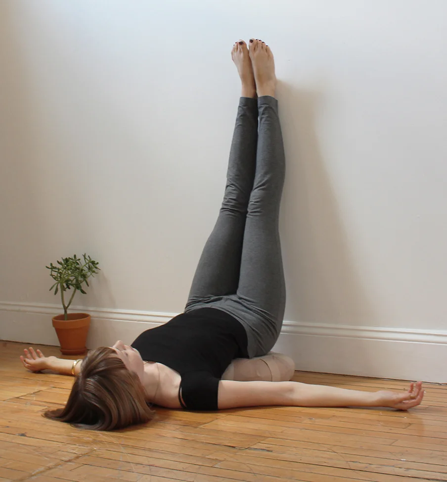 It can be a bit awkward to get into the pose: First place a meditation cushion or folded blanket about 6 inches away from a wall. Then sit one side on one hip on the cushion with your butt facing the wall so that your legs are running straight along the edge of the floor. Lay back and swing your legs up the wall. Make sure your lower back is centered on the cushion and your shoulders and head are on the floor. You've made it! Now for the best part: close your eyes and take slow deep breaths allowing the mind to quiet.