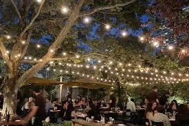 Piccolo Sogno's hidden garden patio at night with twinkling string lights