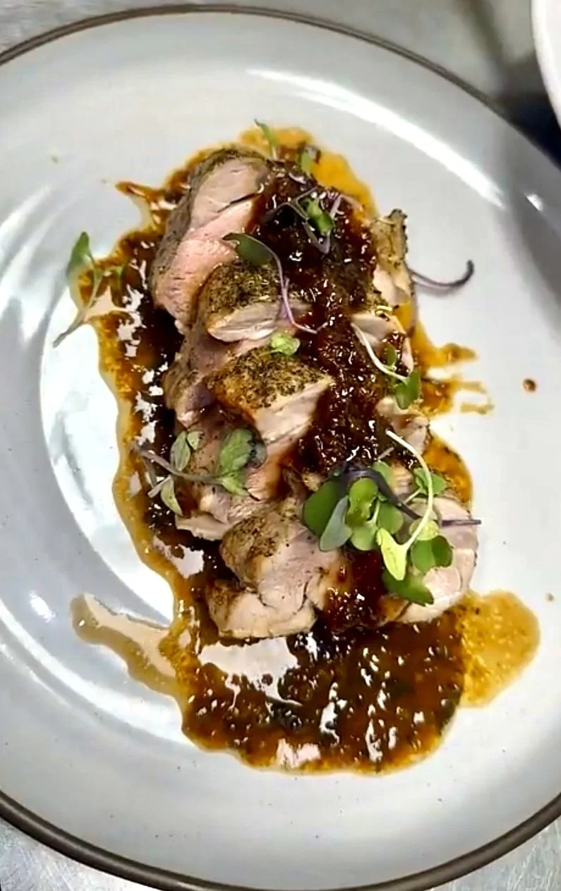   Herb-Crusted Pork Medallions  Sliced pork tenderloin served over a velvety sherry Dijon reduction, finished with a savory bacon jam 