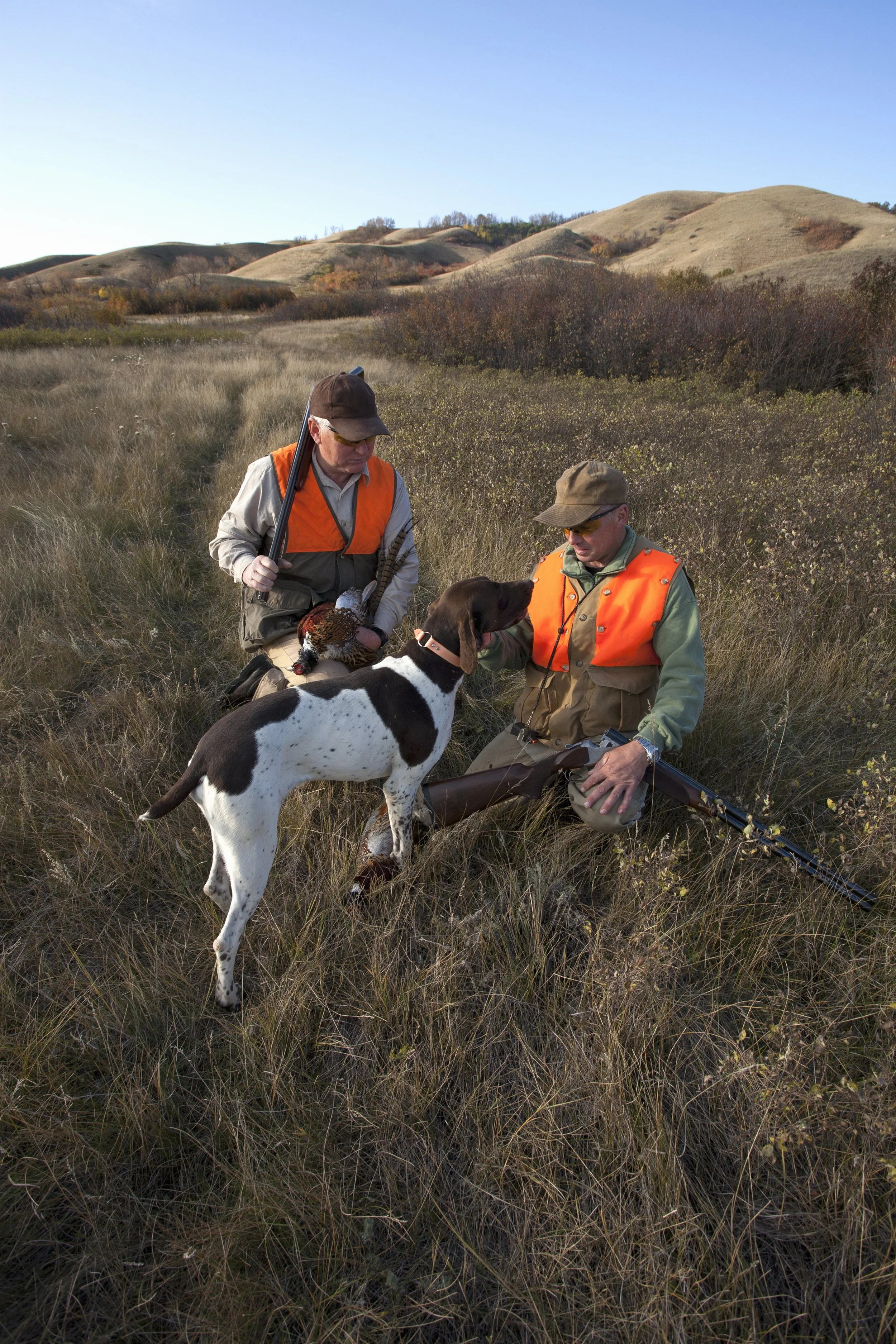 men in hunting gear checking dog