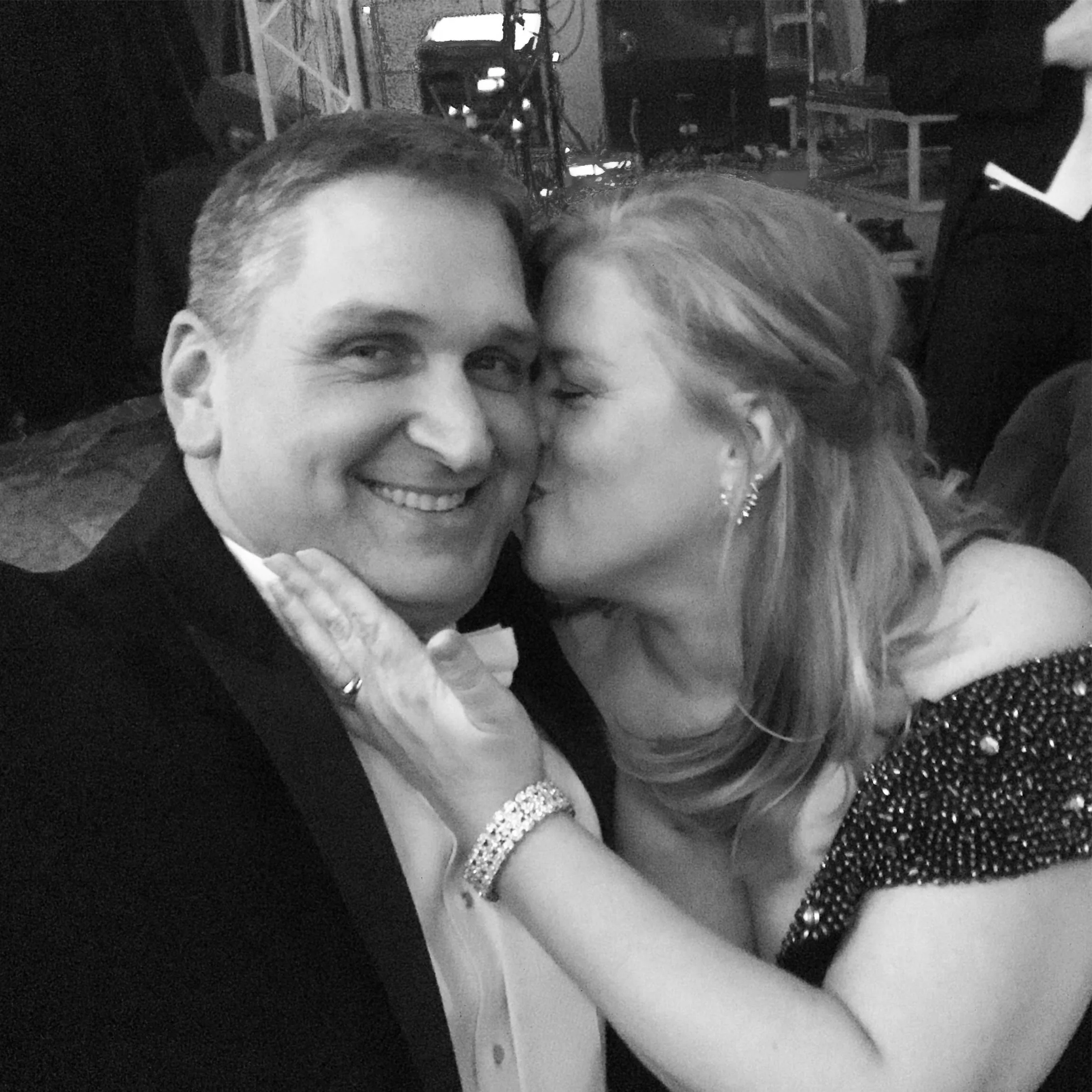 Black and white photo of Brooke and Danny. Brooke is kissing Danny on the cheek.