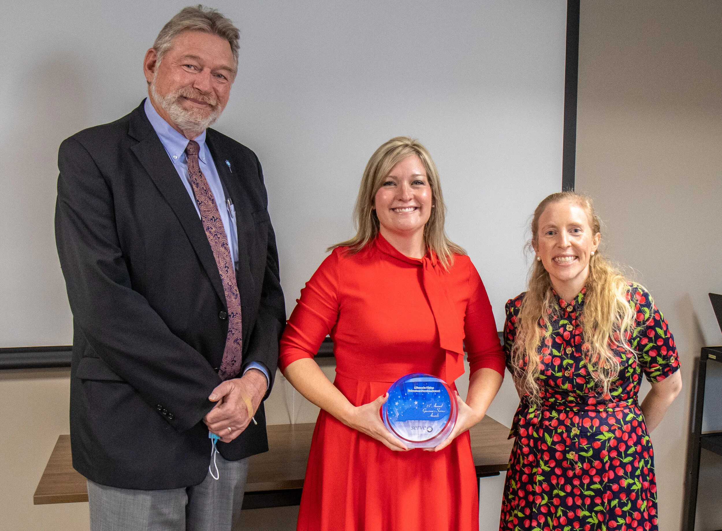 CASA of Lexington Board Member Miranda Wyles, center, accepts the Governor's Volunteer Service Award at CASA of Lexington on Oct. 7. At left is Bourbon County Judge-Executive Mike Williams; at right is CASA of Lexington Executive Director Melynda Jamison.