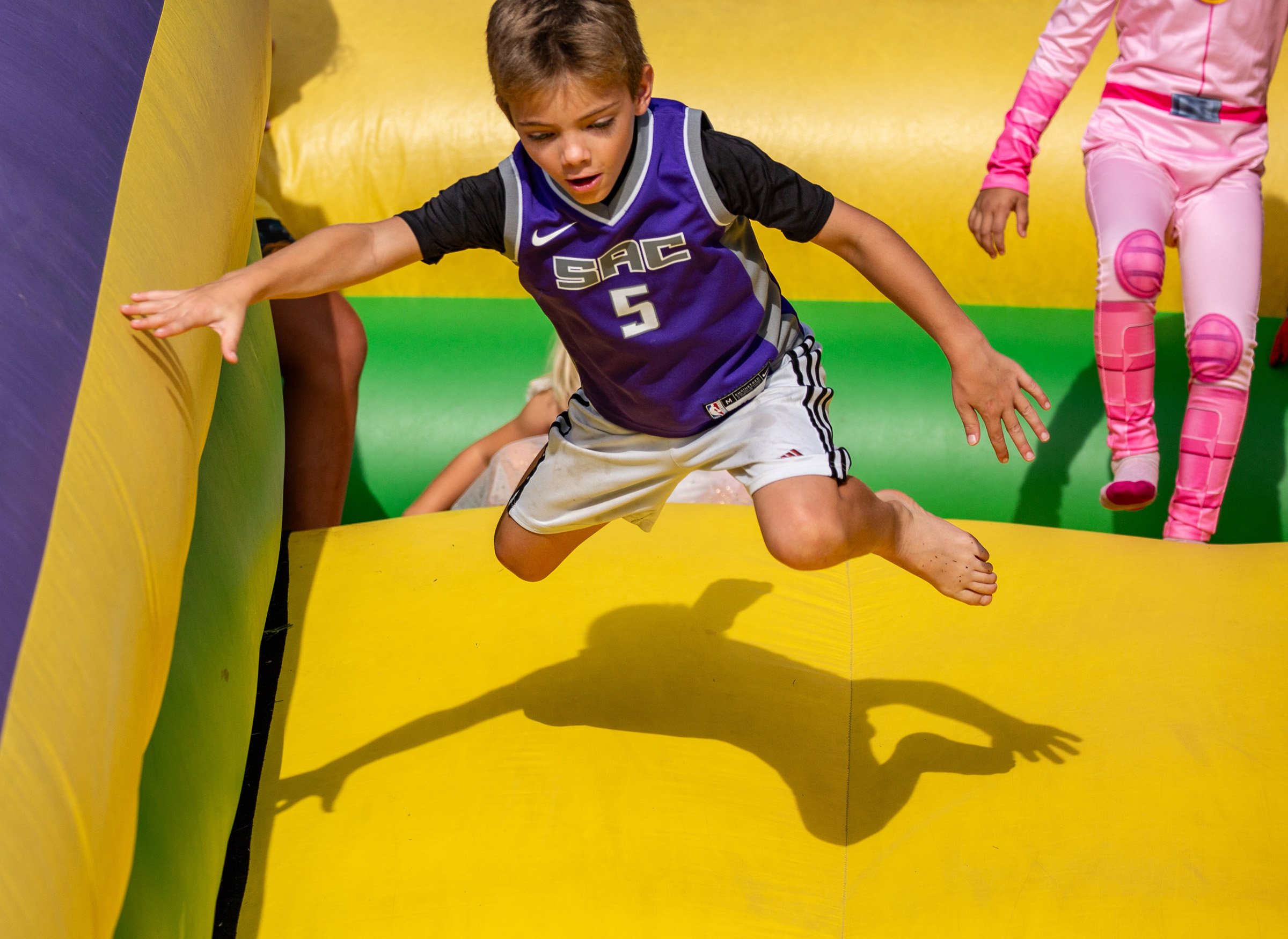 Boy in Purple Jumps Down Slide.jpg