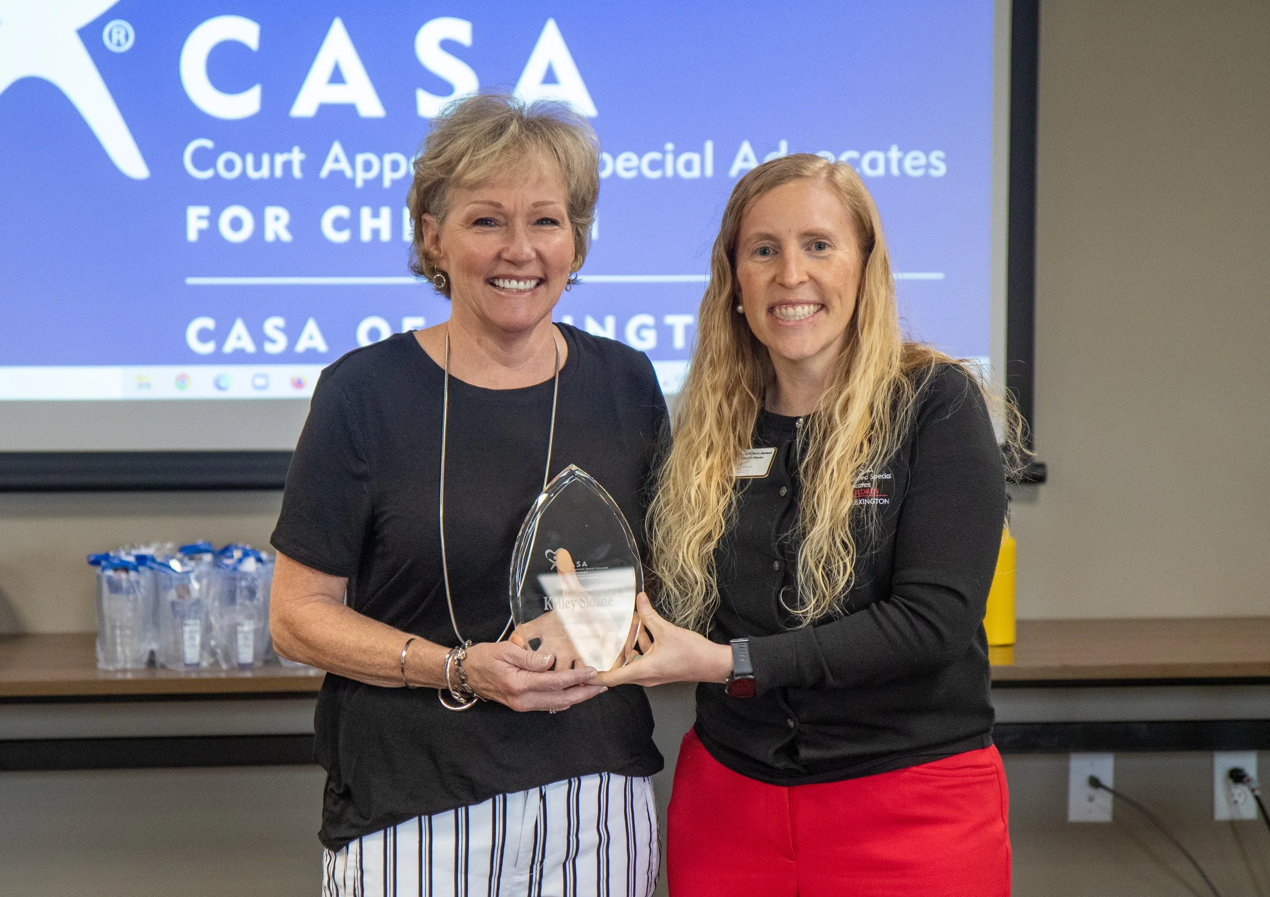 CASA of Lexington Executive Director Melynda Jamison, right, presents CASA volunteer Kelley Sloane with the nonprofit’s first ever Volunteer Achievement Award for her dedication to a single CASA case over eight years.