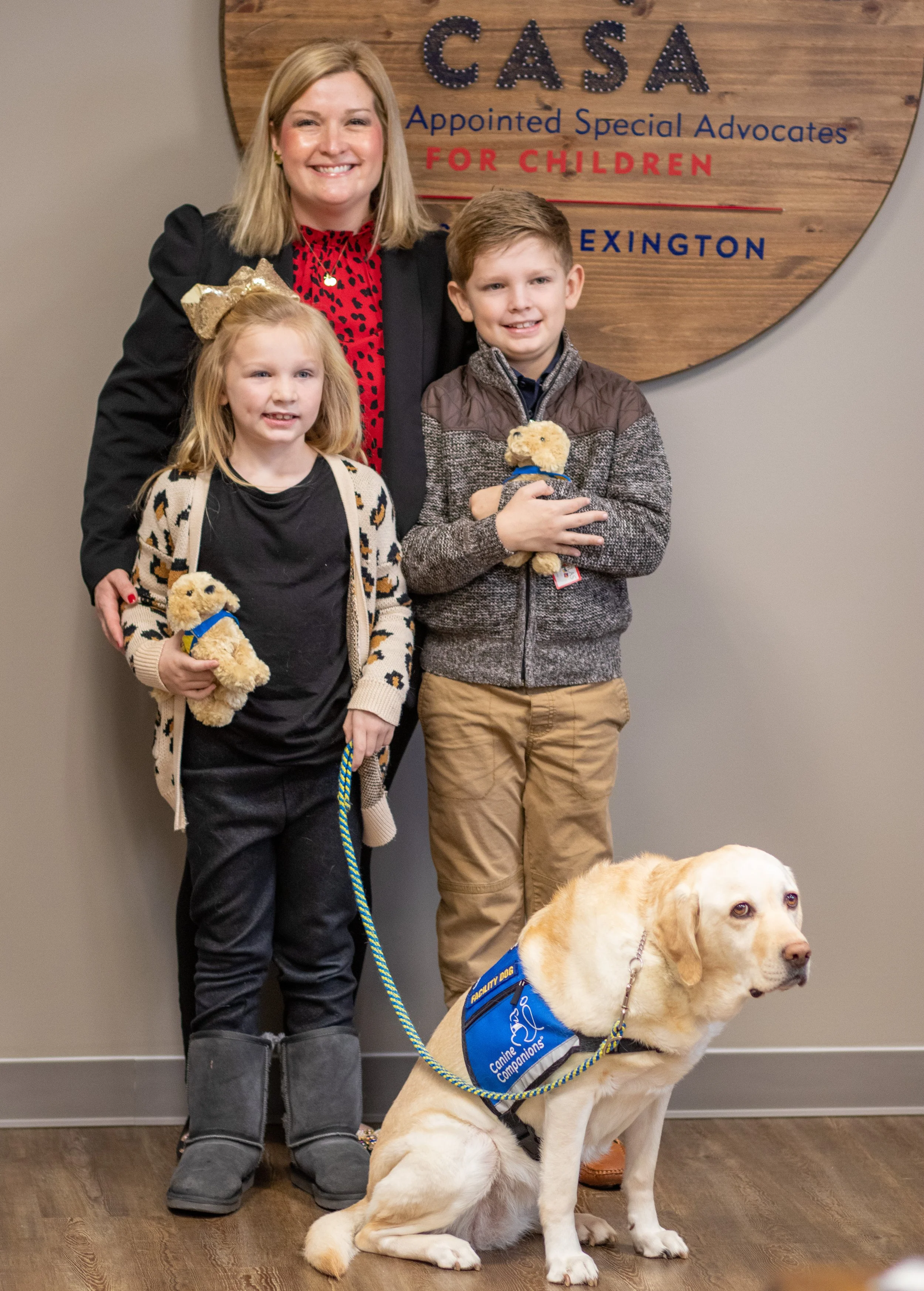Miranda Wyles poses for a photo with her children, Delta and JW, and Matilda, CASA of Lexington’s certified courthouse facility dog.